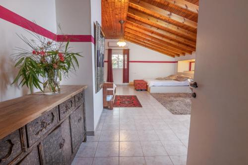 a room with a bed and a vase of flowers on a counter at Nesbehadnes in Had Nes