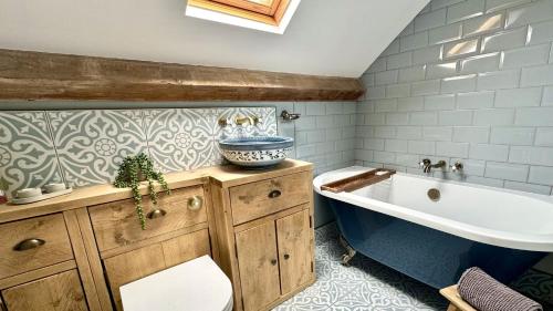 a bathroom with a bath tub and a sink at Ty Coets in Llanfairpwllgwyngyll