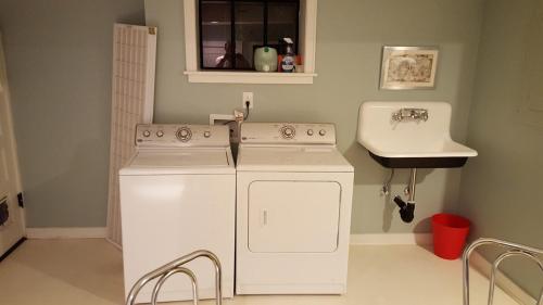 a kitchen with two washing machines and a sink at Clinker Cottage Garden Apartment - Free Breakfast! in Albany
