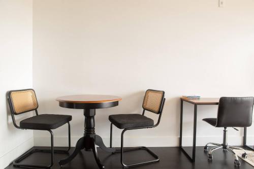 a table and three chairs and a table and a table at Modern Studio Apt with Rooftop, Gym, and Parking in Milwaukee