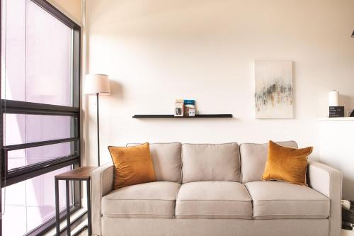 a living room with a couch and a window at Modern Studio Apt with Rooftop, Gym, and Parking in Milwaukee