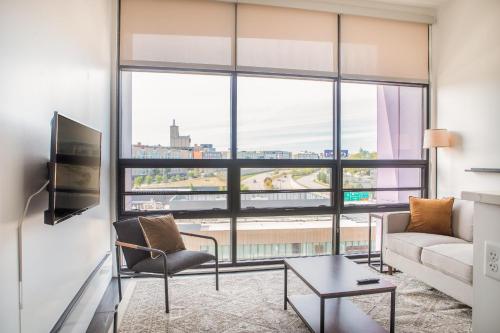a living room with a couch and a large window at Modern Studio Apt with Rooftop, Gym, and Parking in Milwaukee