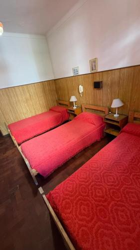 two beds in a room with red covers at Hotel San Carlos in Mar del Plata