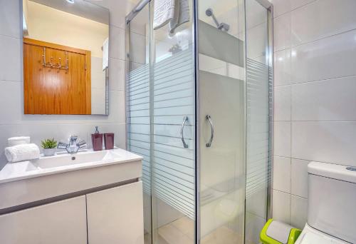 a bathroom with a glass shower and a sink at Vilamar 2 - Madeira Inn Group in Calheta