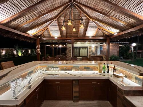 an outdoor kitchen with a bar with wine glasses at Casa por Temporadas in Santa Cruz de la Sierra