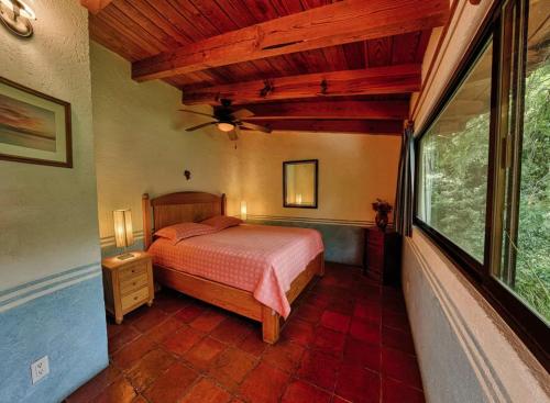 a bedroom with a bed and a large window at Casa navacoyan A in Malinalco