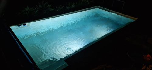 a pool of blue water in a dark room at House with a heated pool for your exclusive use in Santa Brígida