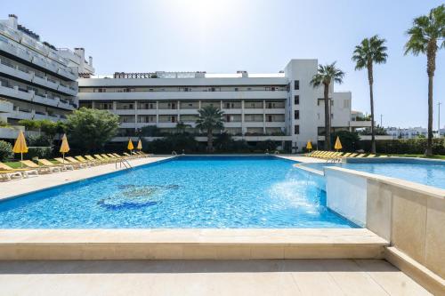 a swimming pool in front of a building at Penthouse Triplex L25 T2 by HsR Vilamarina in Vilamoura