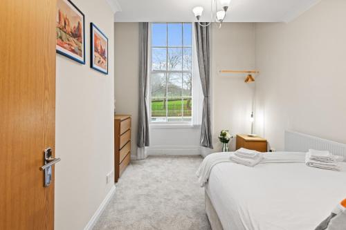 a white bedroom with a bed and a window at Spacious 2 Bed Apartment With Secure Free Parking in Liverpool