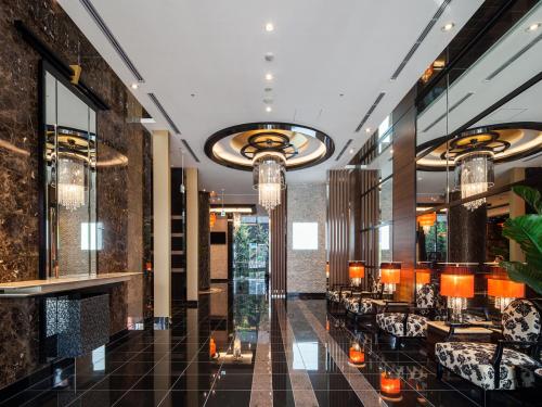a lobby with tables and chairs and chandeliers at APA Hotel Sugamo Ekimae in Tokyo