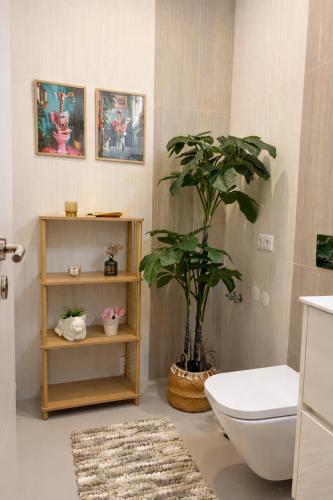 a bathroom with a toilet and a potted plant at Almeida's House in Viana do Castelo