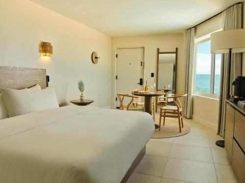a hotel room with a bed and a table and chairs at Ambros Daytona, Trademark Collection by Wyndham in Daytona Beach