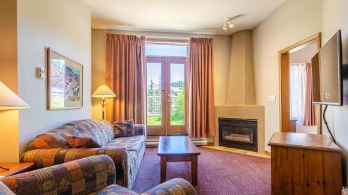 a living room with a couch and a fireplace at Cahilty #110 home in Sun Peaks