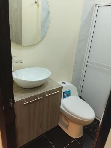 a bathroom with a sink and a toilet and a mirror at Hotel y parqueadero La Colonia Inn in Socorro