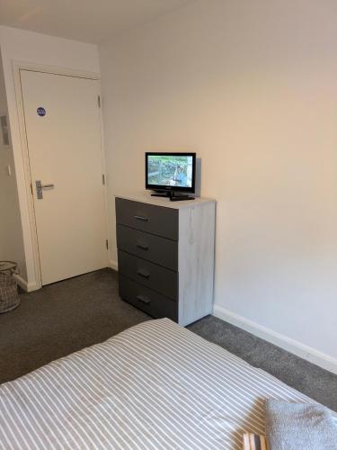 a bedroom with a bed and a television on a dresser at Special Offer CORBY En- Suite Double Room Near Rockingham Min 4 night stay for Couples or Single person Available in Shared property & fully equipped in Rockingham
