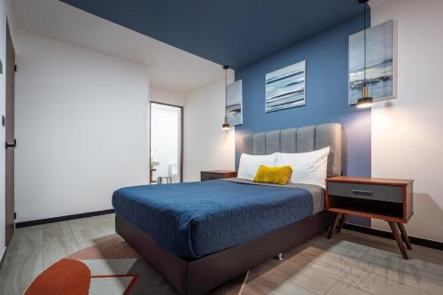 a bedroom with a bed with a blue wall at Exclusive Urban HomeResort in La Cañada