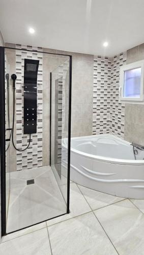 a large bathroom with a tub and a shower at Maison vacances avec piscine Pennautier in Pennautier