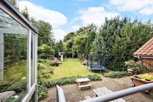 a garden with a picnic table and a playground at Cozy House Close to Beach and B&O in Struer