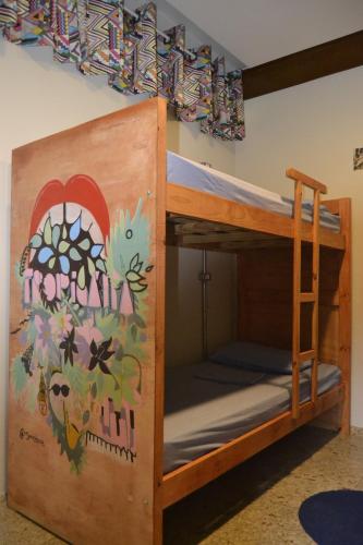 a bunk bed with a mural on the wall at Nomade In Arte e Hostel São Paulo in Sao Paulo