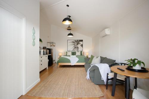 a living room with a bed and a table at Tallows Studio -Modern, tranquil, dog friendly,2 mins to the beach in Suffolk Park