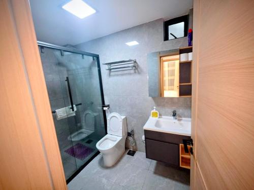 a bathroom with a shower and a toilet and a sink at Skyline Luxury 17th-Floor 1BR near Junction Mall - City Views, Pool, Gym & Full-Body Massage Chair in Nairobi