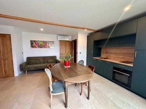 una cucina e una sala da pranzo con tavolo e sedie in legno di Ferme Ihartzetako ad Ascain