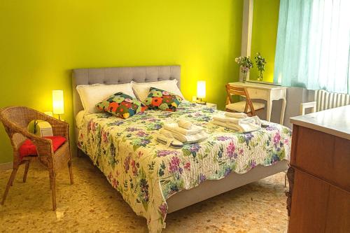 a bedroom with a bed and a table and a chair at Camera Verde vicino alle Mura - Madame Fannj in Lucca