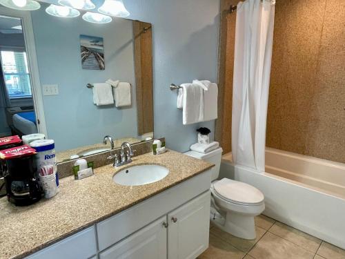 a bathroom with a sink and a toilet and a mirror at Beachgate Condo Suites and Hotel 537a condo in Port Aransas