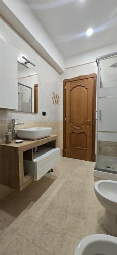 ein Badezimmer mit Waschbecken und Holztür in der Unterkunft Jo Garden in Ercolano