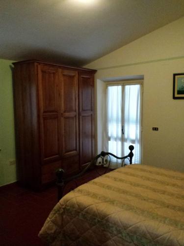 a bedroom with a bed and a large wooden cabinet at La Macina di Bettona in Bettona