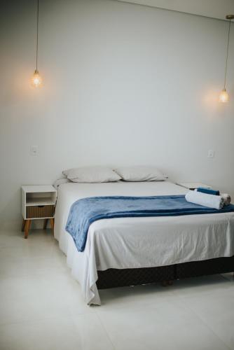 a bedroom with a bed with a blue blanket on it at casa com piscina in Sinop
