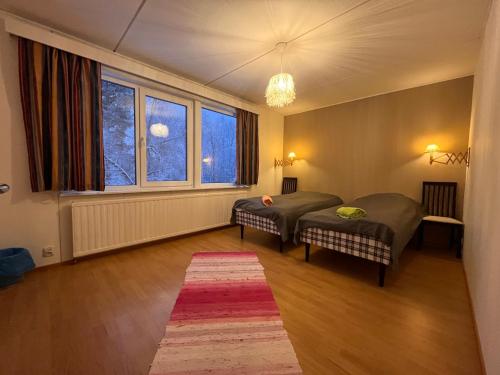 a room with two beds and a large window at Juurikkalahti Adventure Center in Kajaani