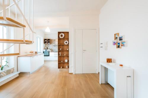 a kitchen with white cabinets and a wooden floor at Sunset Terrace Sorrento Coast in Sant'Agnello