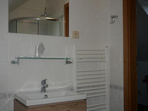 a white bathroom with a sink and a mirror at Hotel Elsyn Dvůr in Stachy