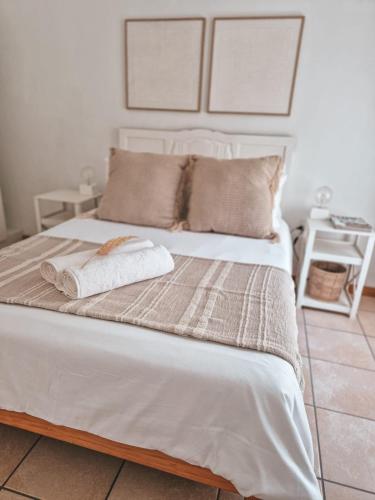 a white bed with two towels on top of it at Dan en Wan in Agulhas