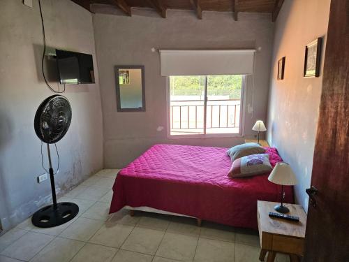 a bedroom with a pink bed and a window at MARTIN TENIS CLUB in Navarro