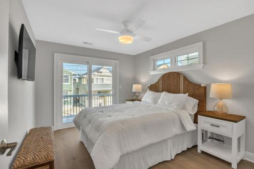 a white bedroom with a bed and a window at 1220 A Asbury in Ocean City