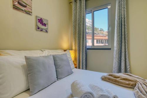 a bedroom with a white bed with a window at Vilamar- Madeira Inn Group in Calheta
