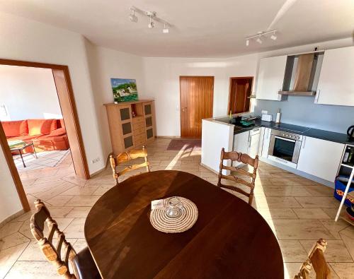 a kitchen and dining room with a wooden table and chairs at Ferienwohnung Schwarzwald - Nähe der Schweiz in Hüfingen