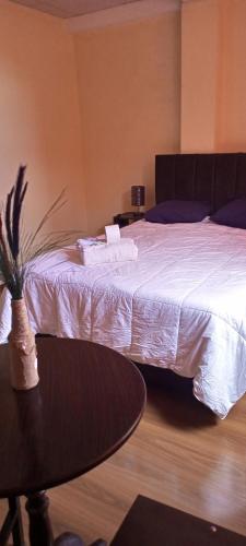 a bedroom with a large bed with a table and a table sidx sidx at Casa Sajama 121 in La Paz