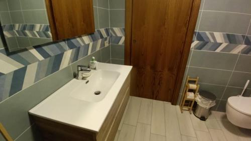 a bathroom with a sink and a toilet at Ospitalità Adocentyn in Guinadi