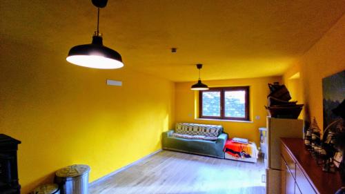 a living room with a couch and two pendant lights at Ospitalità Adocentyn in Guinadi