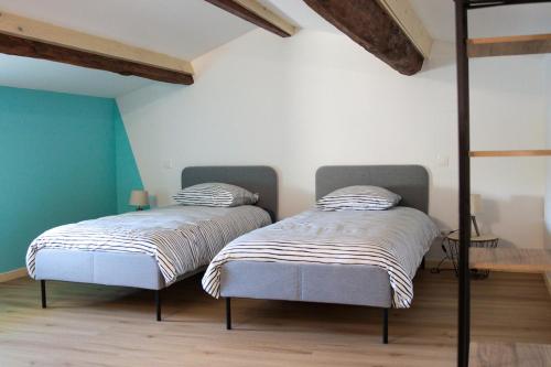 two beds sitting next to each other in a room at Gîte des forgerons in Sainte-Ouenne