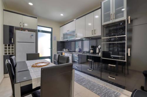 a kitchen with a dining table and a kitchen with appliances at Vilamar- Madeira Inn Group in Calheta