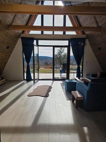 a living room with a blue couch and a large window at Panta Nature House in Dobrodoli