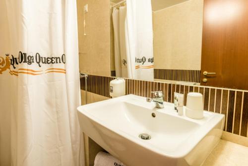 a bathroom with a white sink and a mirror at Queen Olga Hotel in Thessaloniki