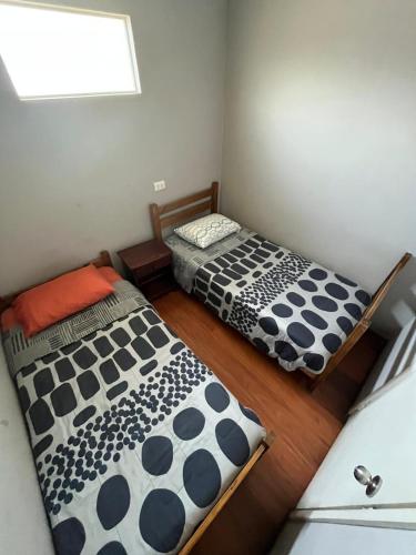 two beds sitting in a room with a window at Hostal JV CABAÑA in Nogales