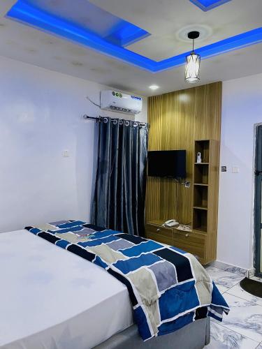 a bedroom with a bed with a blue ceiling at Wesmont Hotels in Ikorodu