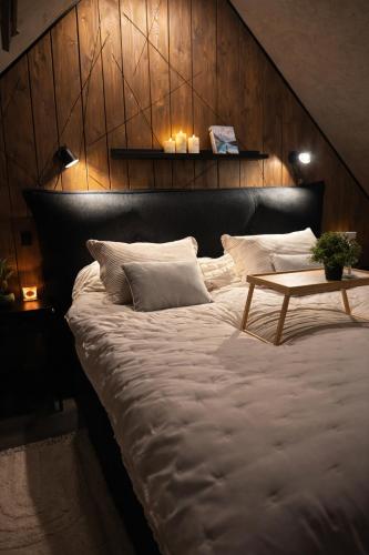 a large bed with a wooden headboard with a table on it at Slava Spa Relax House in Nakskov