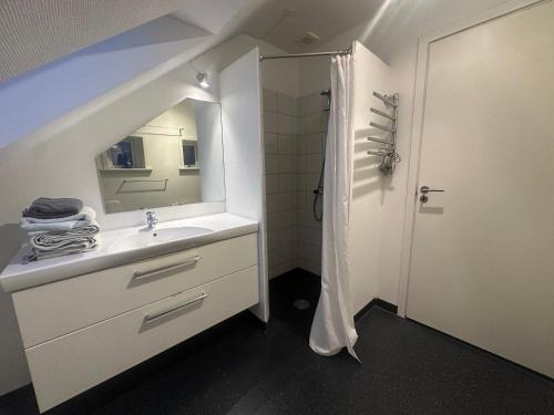 a white bathroom with a sink and a shower at Apartment in the center of Herning in Herning